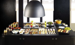 Een overvloedig ingerichte buffet met diverse gerechten en drankjes.
