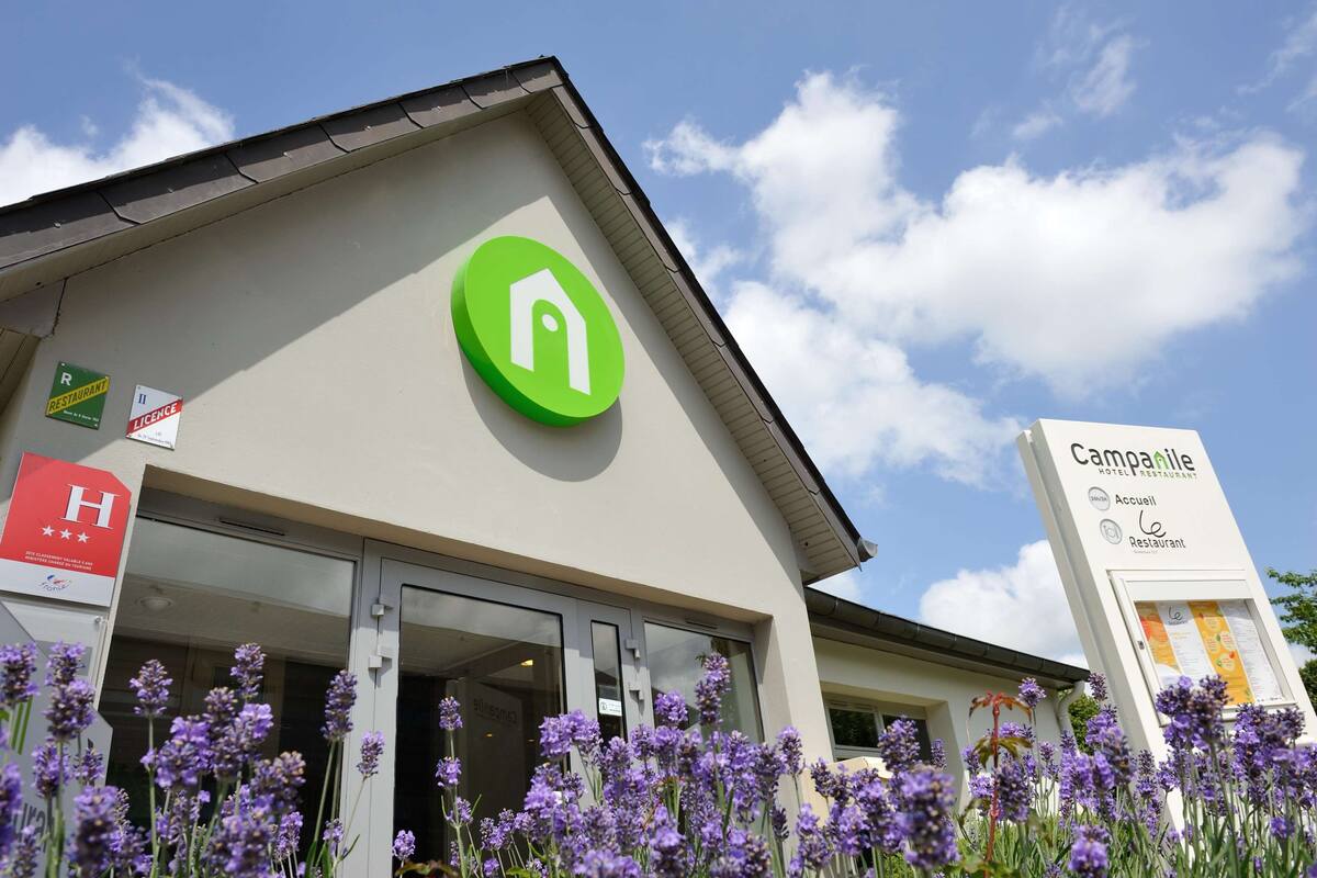 Een hotel met een groen logo, een bord dat een restaurant aangeeft, en een bord voor een hotelrestaurant.