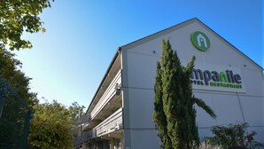 Un edificio con un letrero que dice 'campanile hotel restaurant' y un logotipo verde.