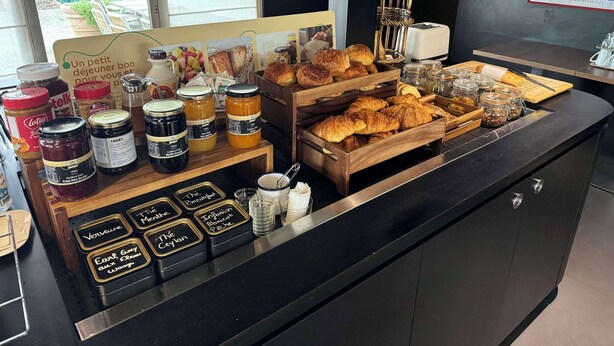 Un bufé de desayuno con diversas opciones de untables, pastelería y salsas.
