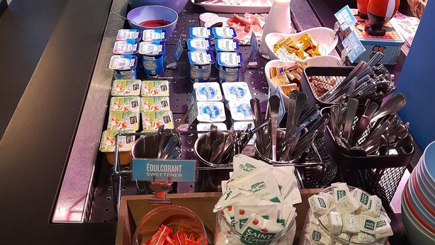 A buffet area with various food items, including fruits, yogurts, and condiments. - Campanile Nature Haguenau (Haguenau)