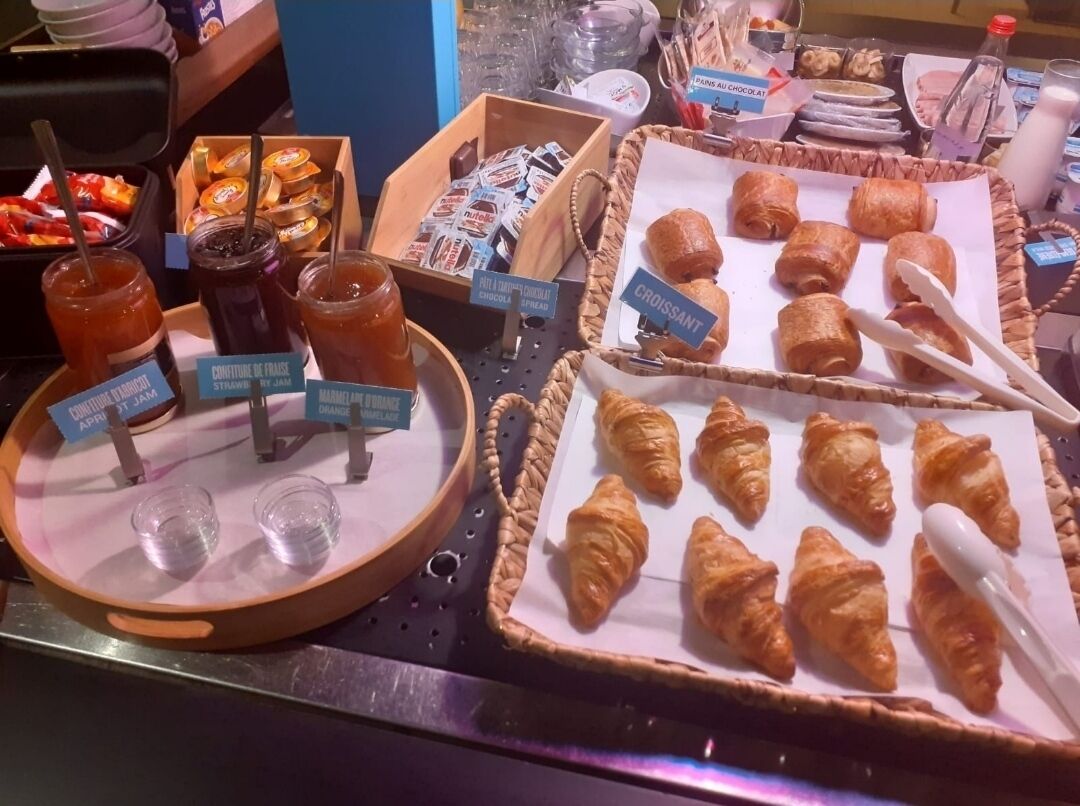 Een ontbijtbuffet met diverse gebakjes, jam en sauzen.