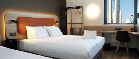 A hotel room with two beds, a desk, a chair, a wardrobe, and a window with a view of a rocket.