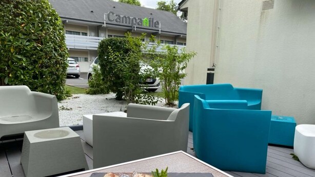 Un área de estar al aire libre con mobiliario moderno y un plato de postre.
