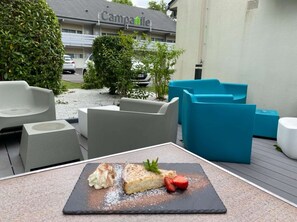 An outdoor seating area with modern furniture and a dessert plate.
