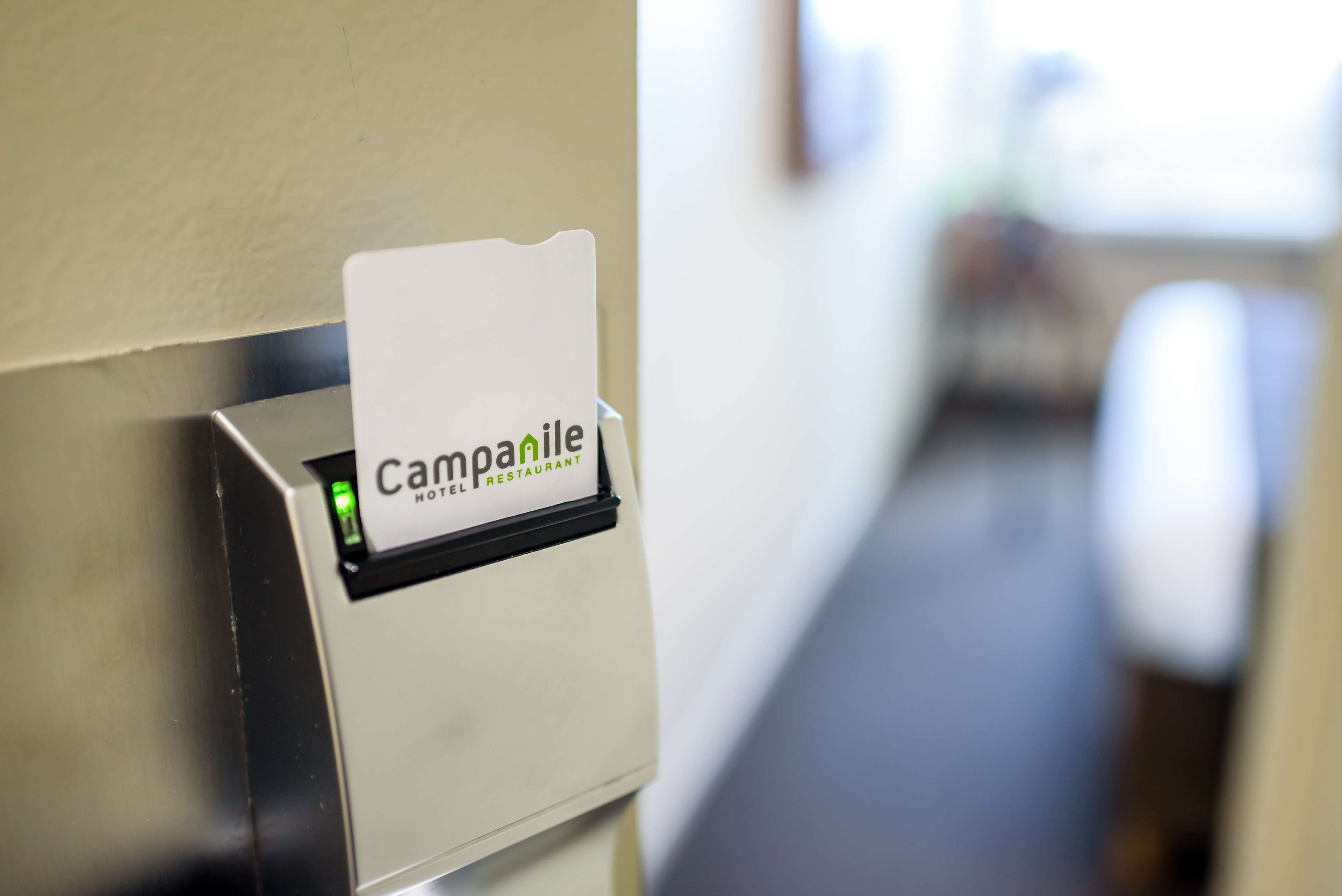 A hotel sign with the name "Campanile Hotel Restaurant" mounted on a wall.