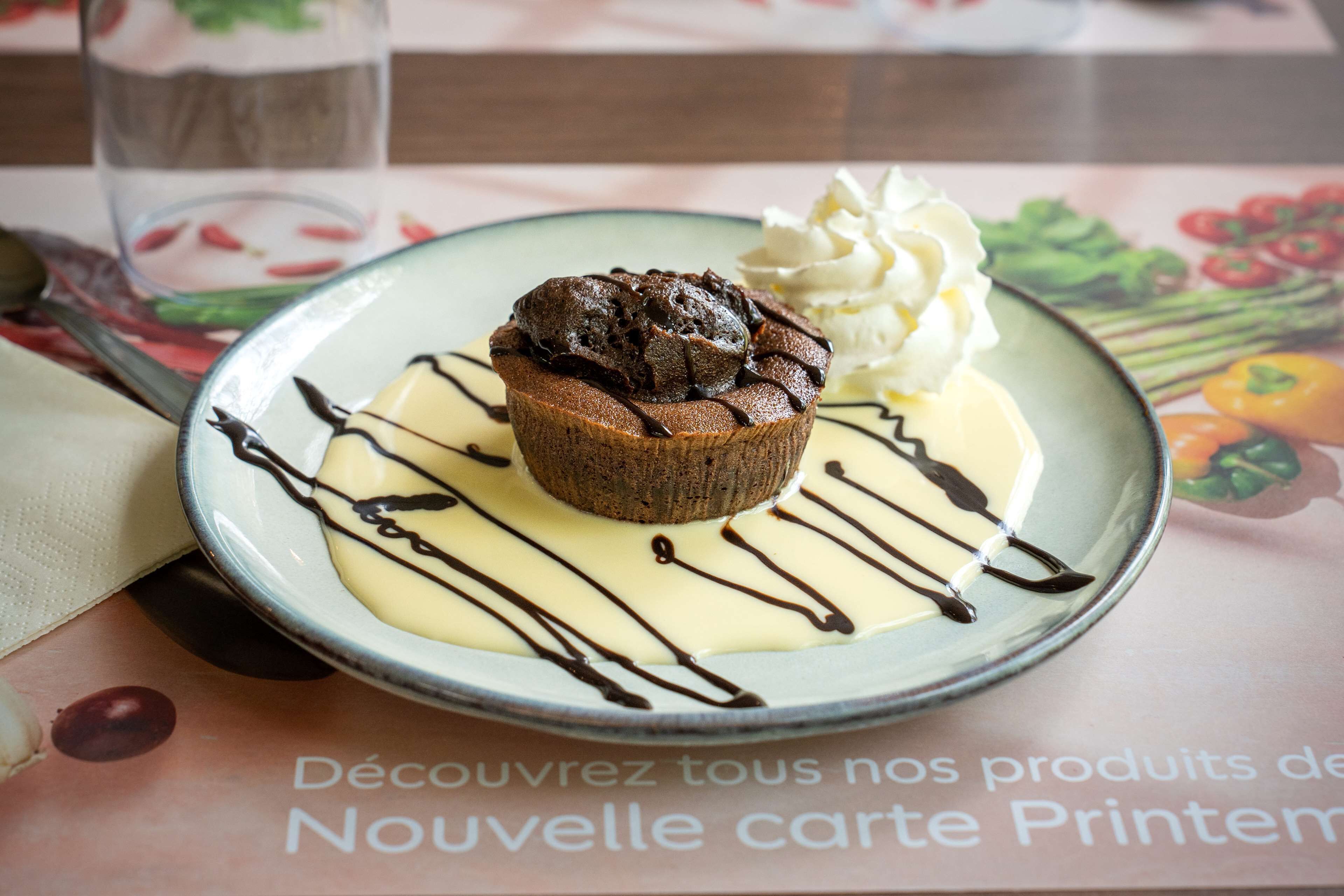 A dessert on a plate with whipped cream and chocolate drizzle.