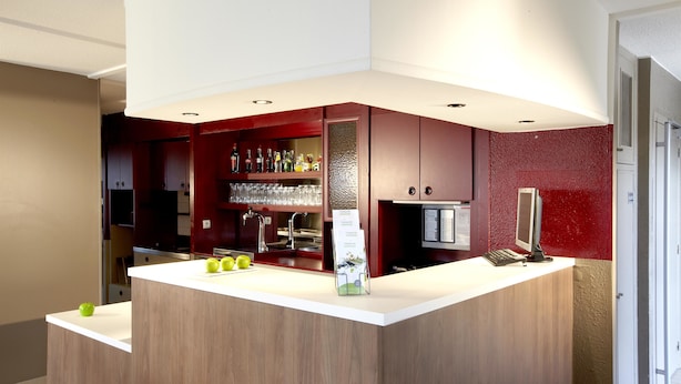 A modern kitchen with a central island, a built-in wine rack, and a refrigerator. - Campanile NATURE - Rouen Nord Mont Saint Aignan (Mont-Saint-Aignan)