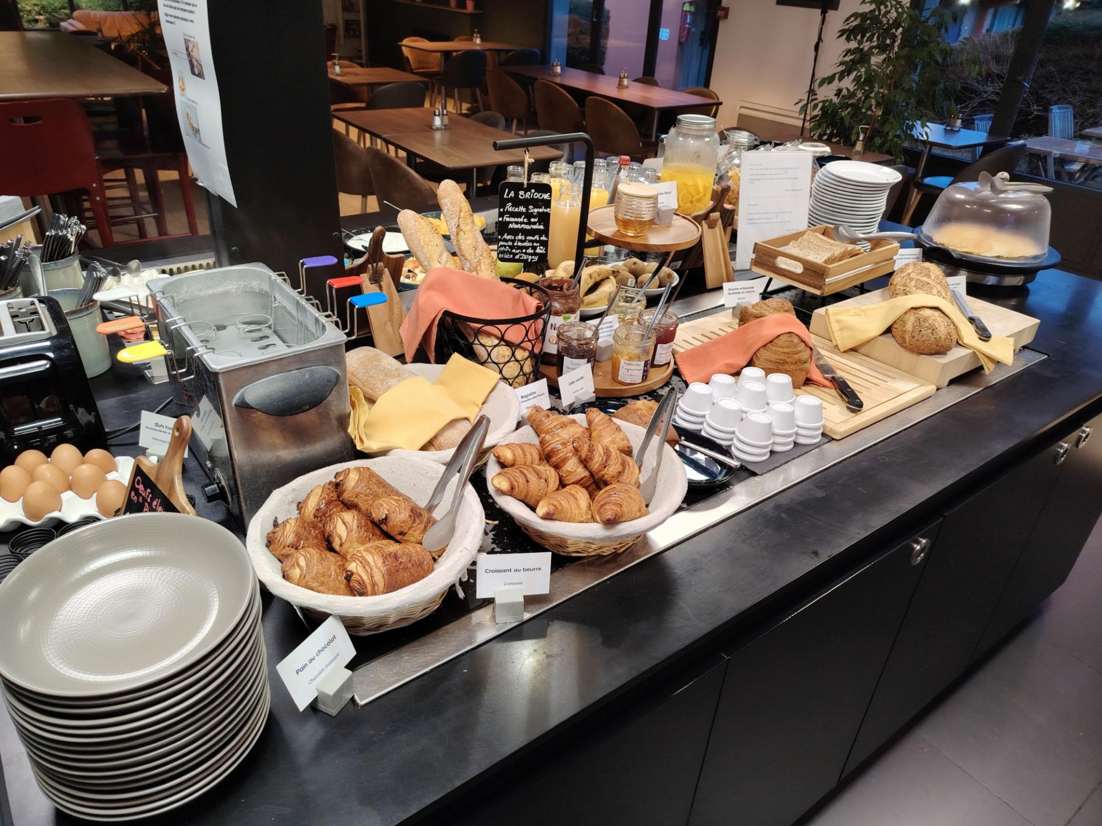 Een ontbijtbuffet met diverse gerechten en een koffiehoek.