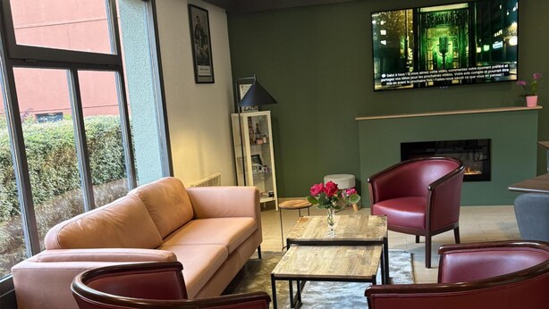 Un salon moderne comprenant un canapé, deux fauteuils, une table basse et une cheminée.