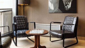 A room with two leather chairs, a chessboard, a lamp, and a horse painting on the wall. - Campanile Bethune Fouquieres (Fouquieres-les-Bethune)