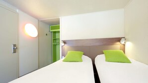 A hotel room with two beds, each with a green pillow, a wooden headboard, and a wall-mounted light fixture. - Campanile Bethune Fouquieres (Fouquieres-les-Bethune)