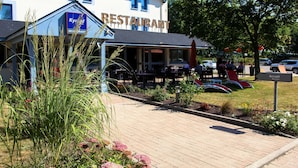 A restaurant with outdoor seating, a sign reading "Kyrid Restaurant," and a reception area labeled "Accueil." - KYRIAD ROUEN NORD - Mont-Saint-Aignan (Mont-Saint-Aignan)