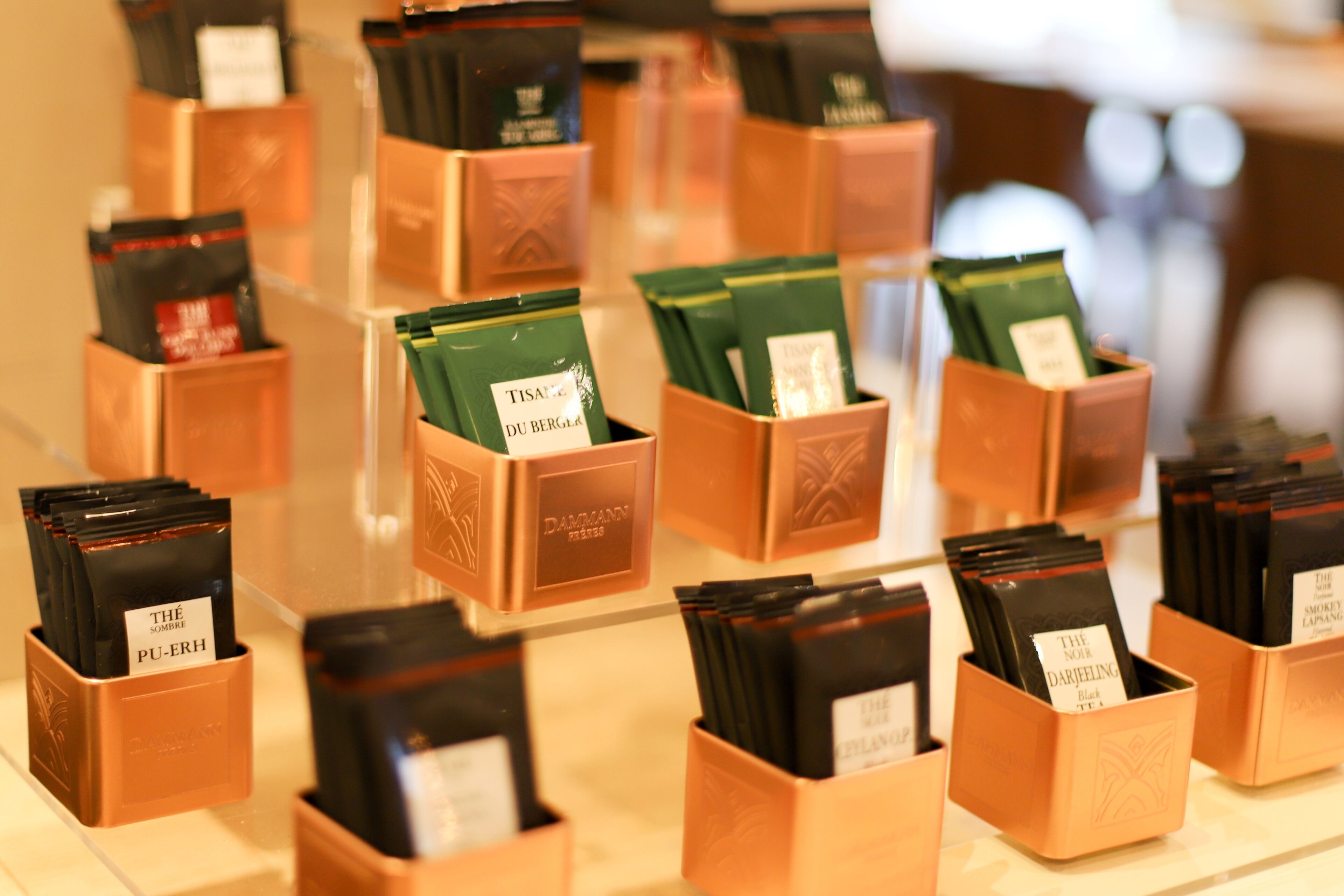 A display of tea bags in copper-colored boxes with labels.