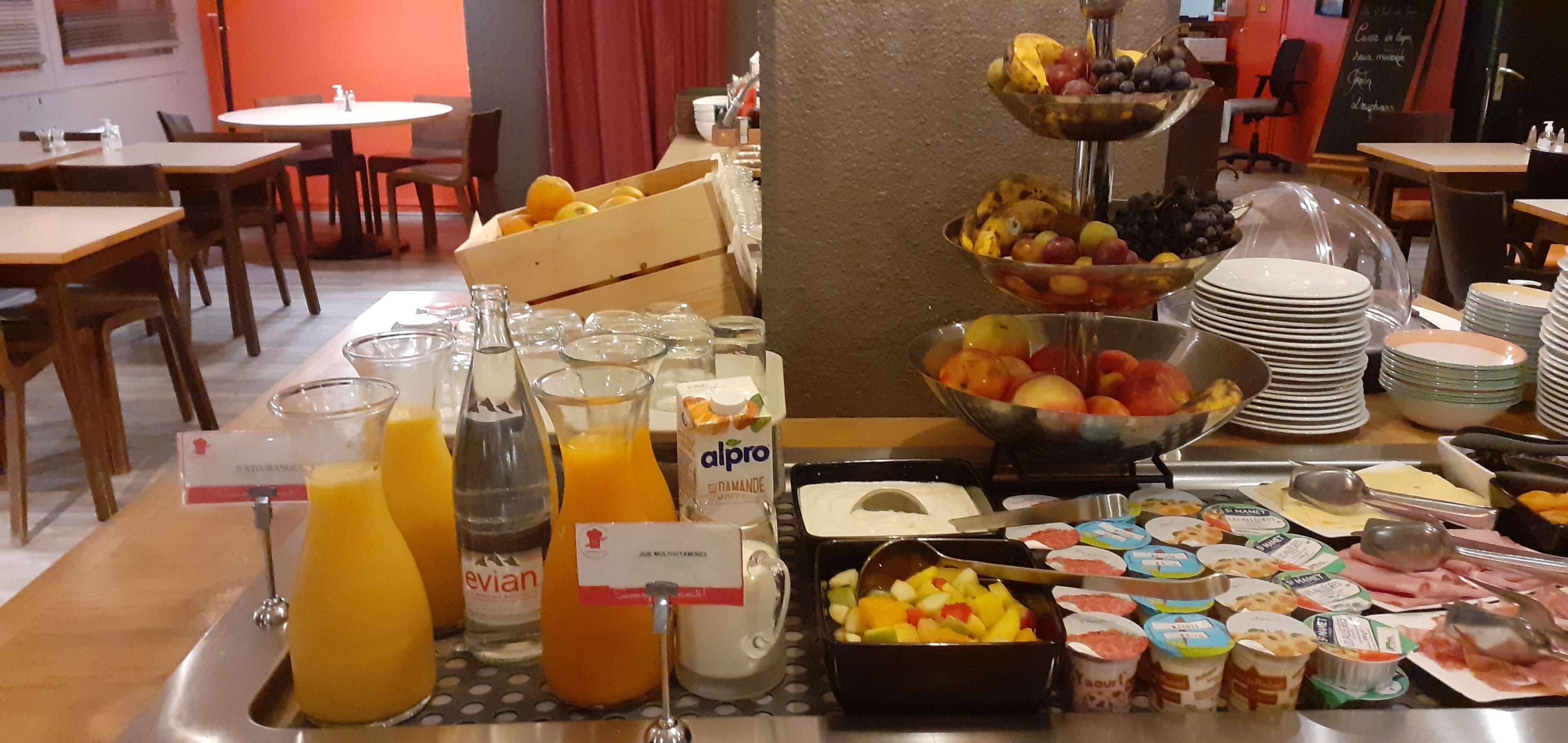 Un bufé de desayuno con diversas frutas, jugos y productos lácteos.