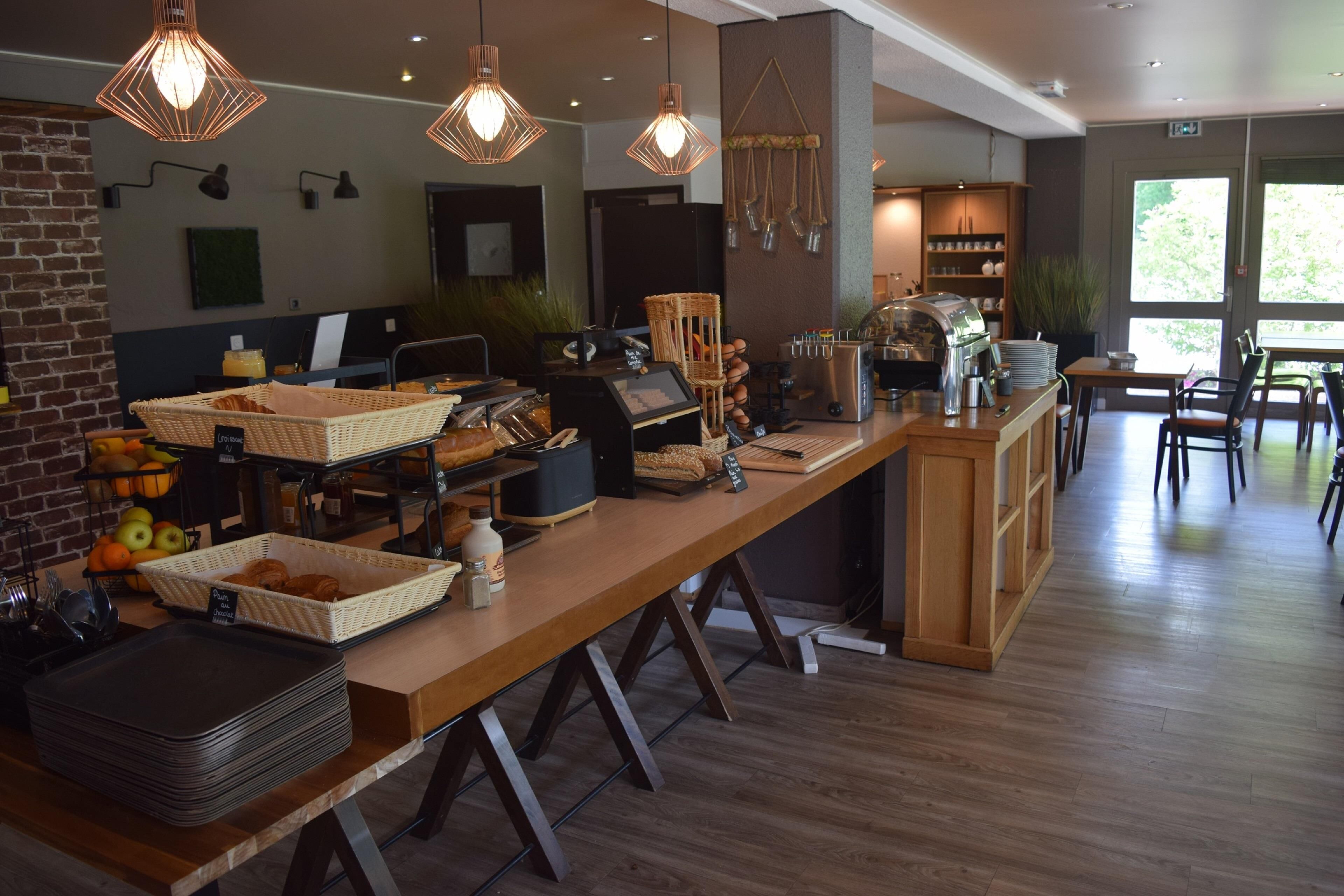A breakfast bar with baskets of bread, a coffee machine, and a buffet area with various food items.