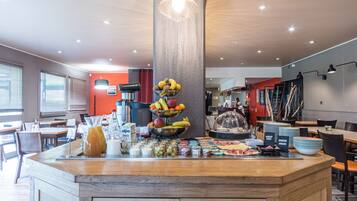 Un buffet pour le petit-déjeuner proposant des fruits, des boissons et divers aliments pour le petit-déjeuner.