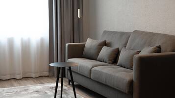 A modern living room with a sofa, a small round table, and a floor lamp.