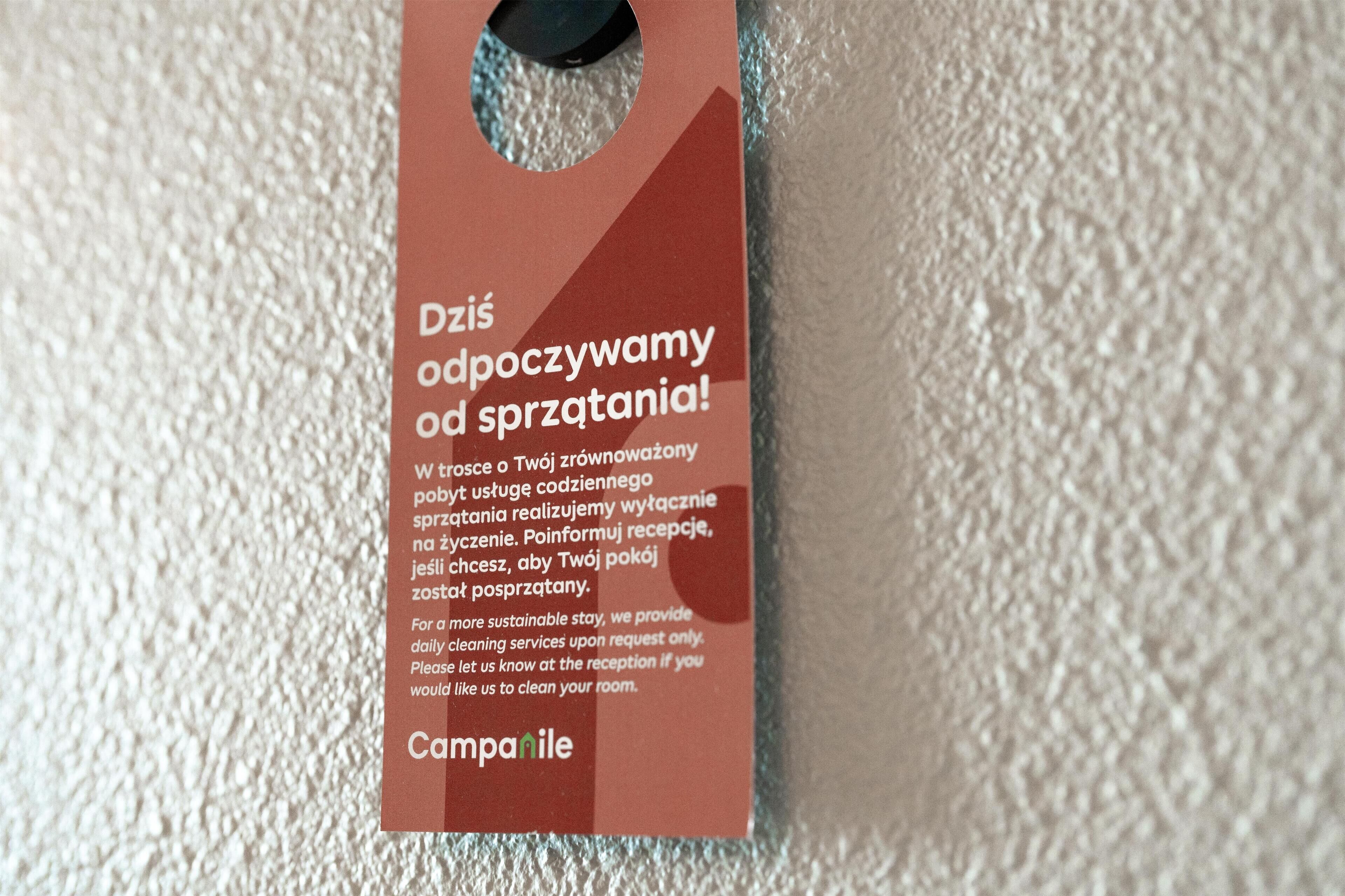 Een label met tekst in Pools en Engels, waarschijnlijk gerelateerd aan hotelvoorzieningen of regels.