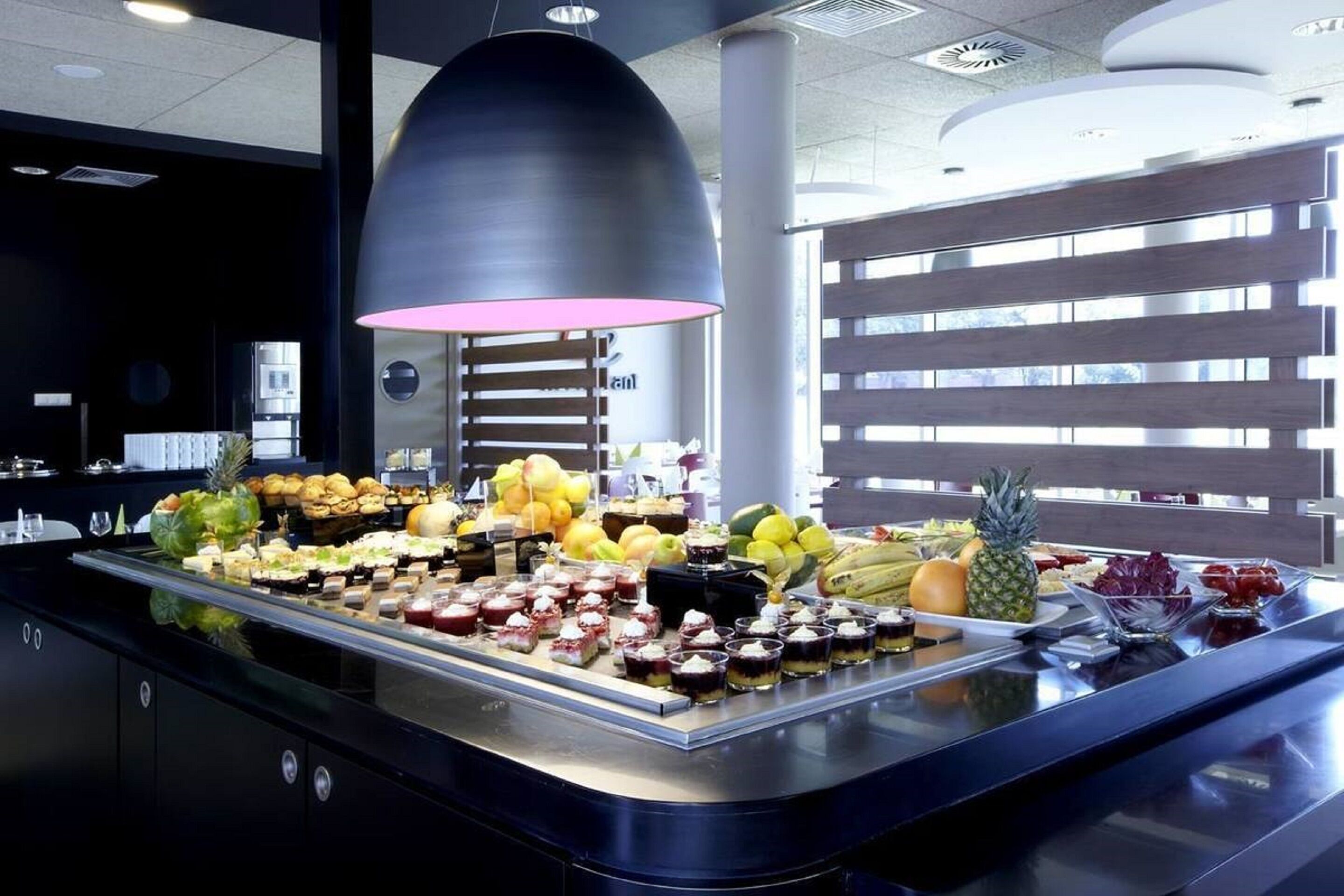 Un buffet proposant une variété de plats et un grand luminaire suspendu.