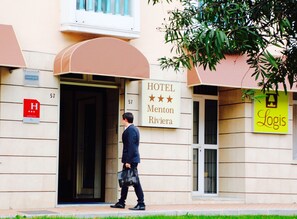 L’entrée d’un hôtel, avec une enseigne indiquant qu’il s’agit du Merton Riviera Hotel.