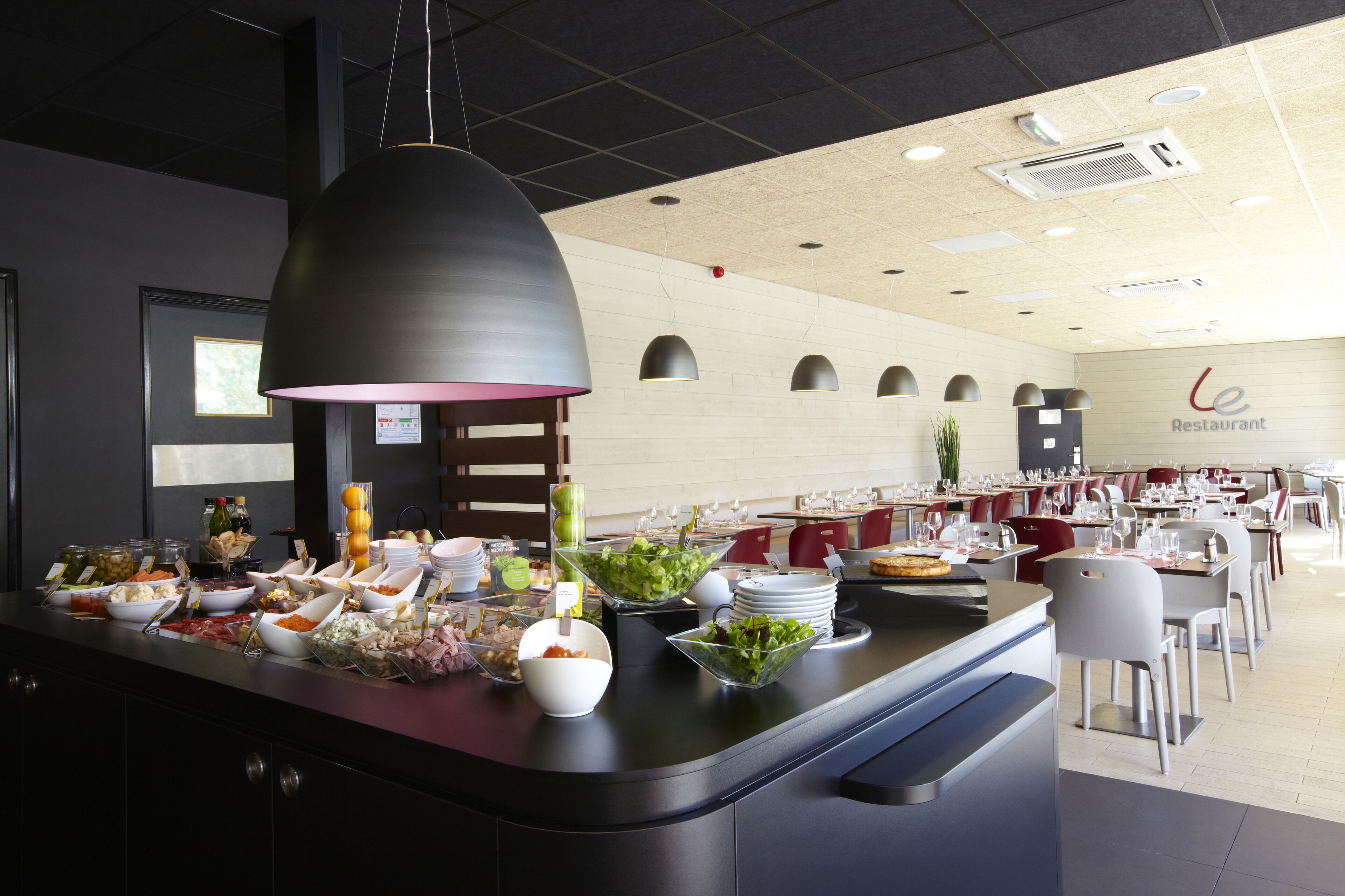 A buffet area with various food items and a seating area in the background.