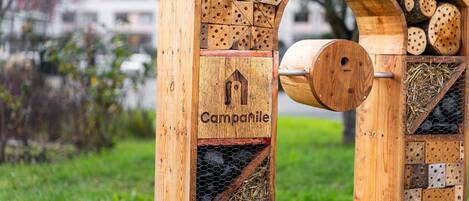 A wooden birdhouse with a house-shaped entrance and the word "Campanile" on it.