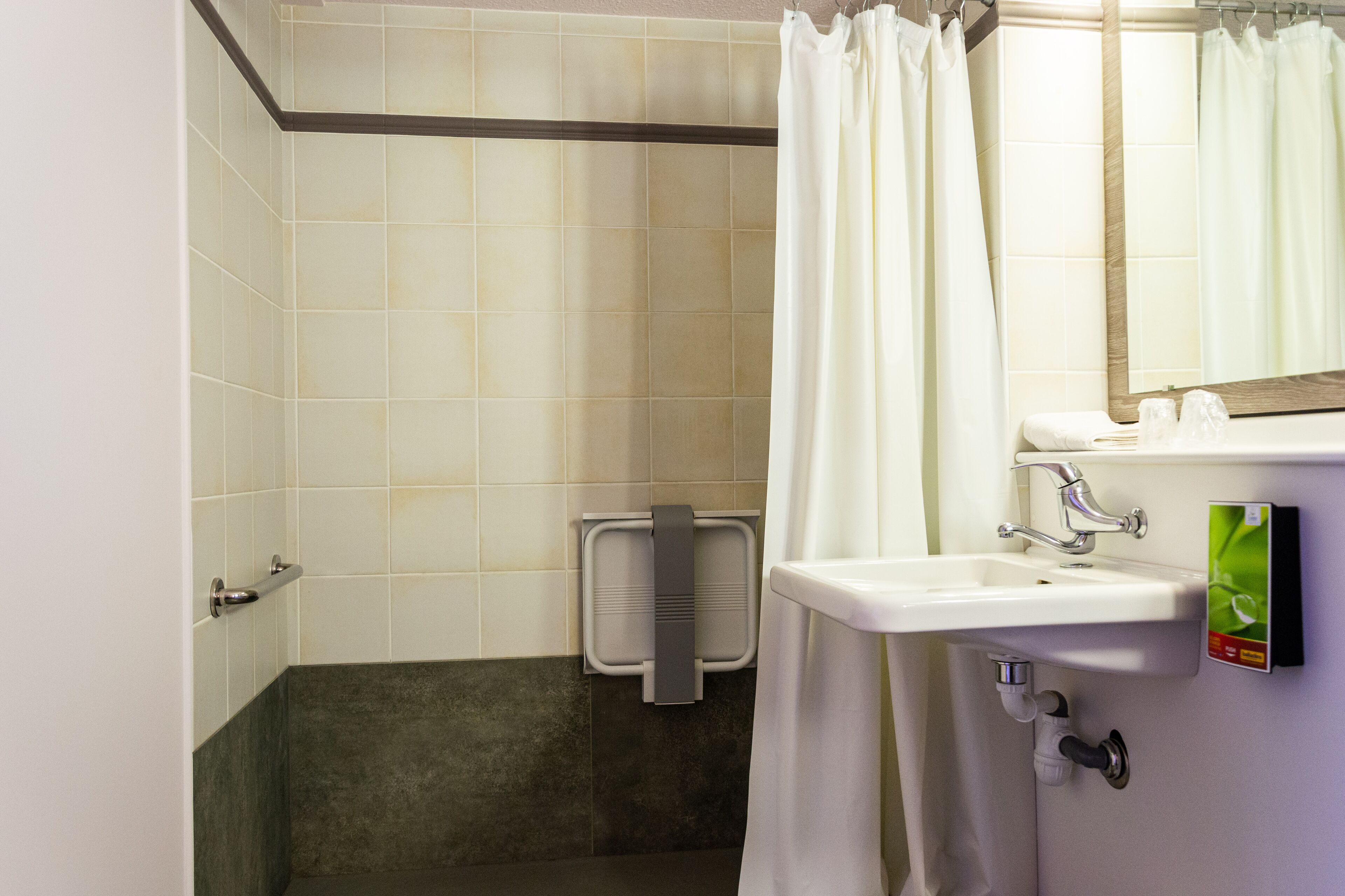 A bathroom with a white sink, a mirror, and a shower curtain.