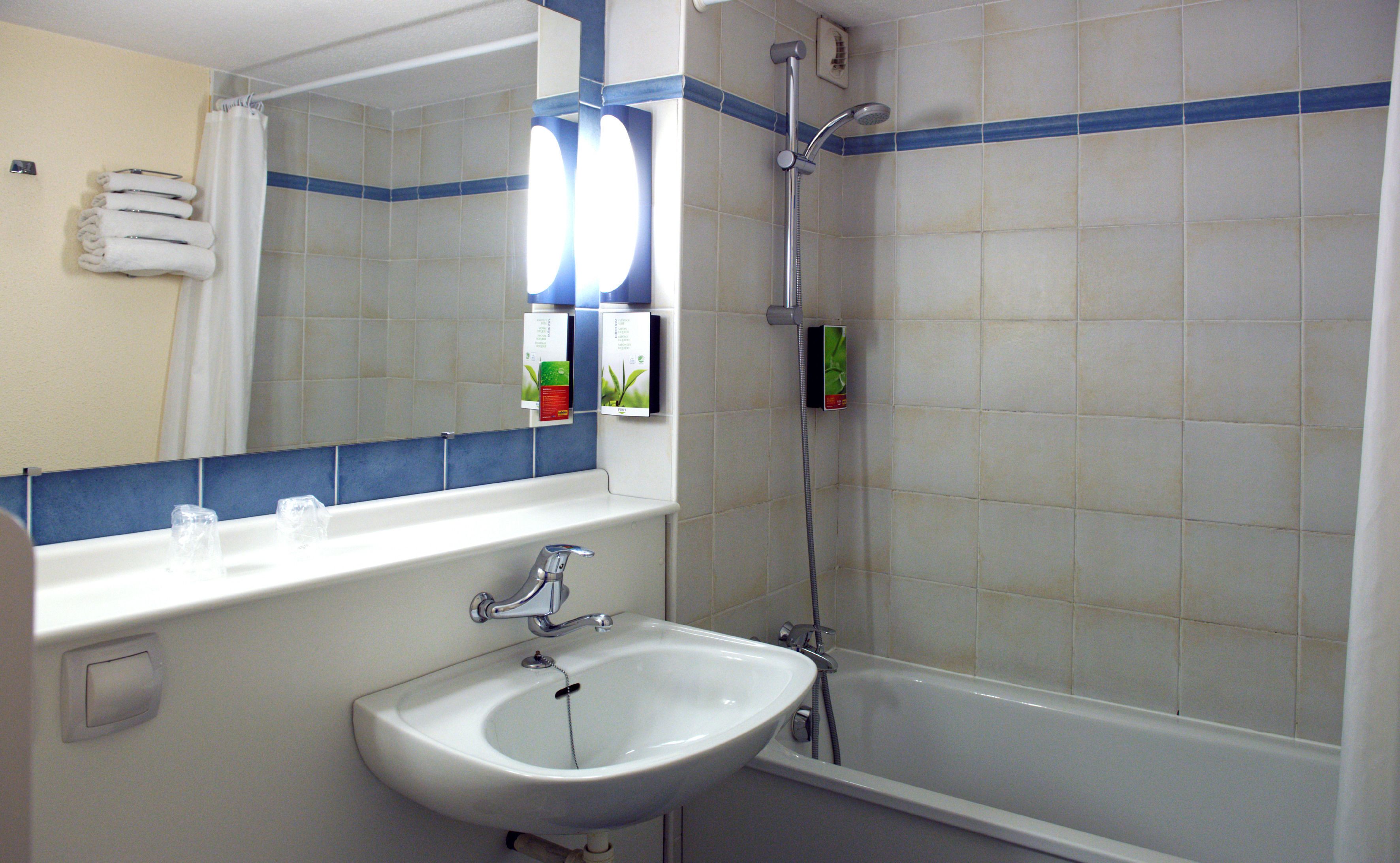 Ein Badezimmer mit Waschbecken, Spiegel und Dusche.