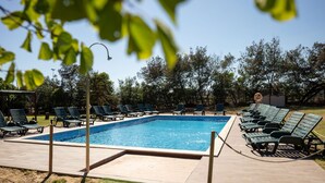 Une piscine rectangulaire entourée de chaises longues.