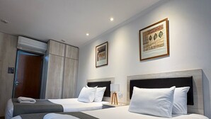 Ein Hotelzimmer mit zwei Betten, einem großen Fenster und einer Tür.