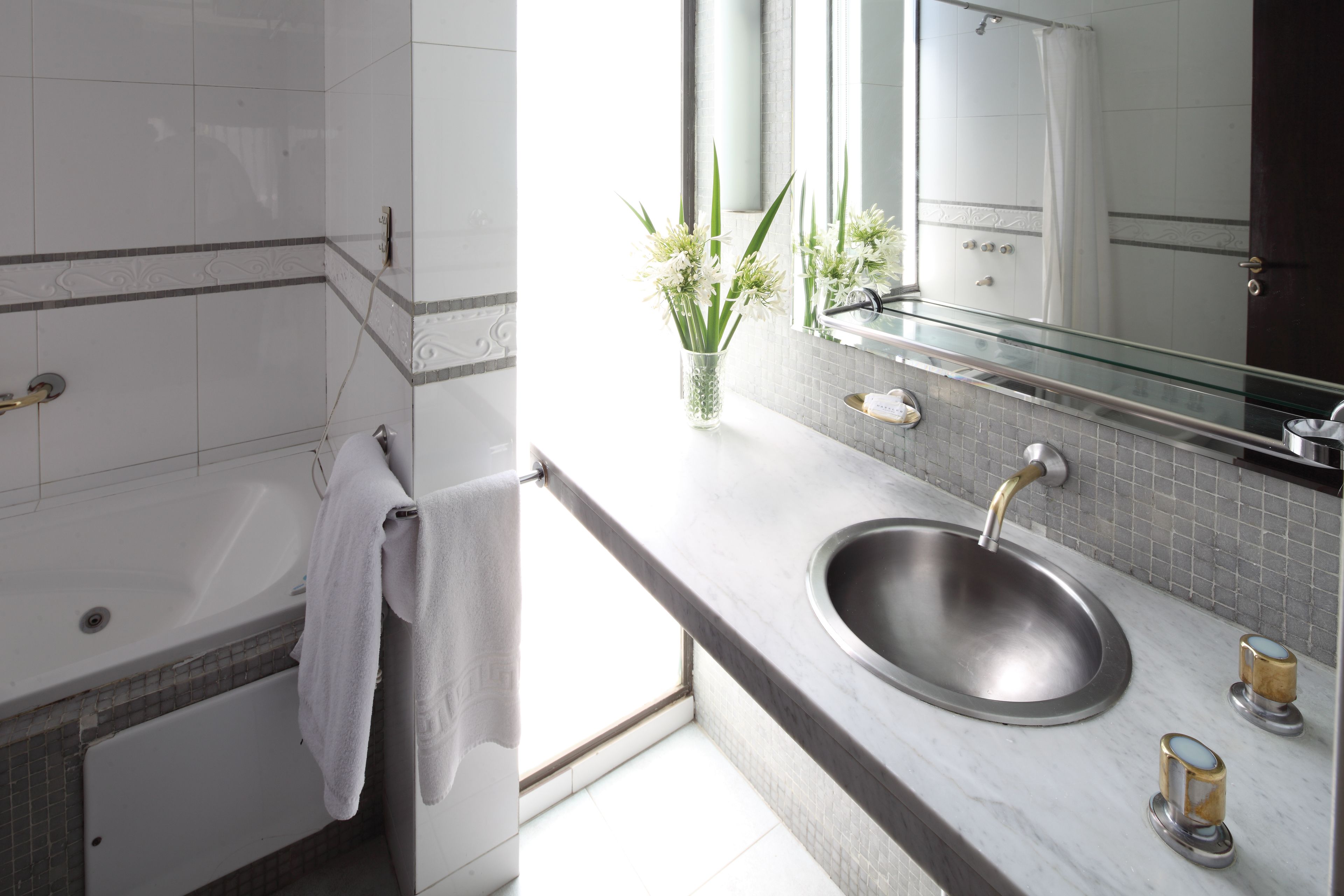 A modern bathroom with a bathtub, a sink, and a mirror.