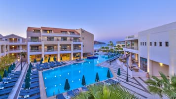 Relax by the pool surrounded by lounge chairs and umbrellas, with stunning views of the surrounding greenery.