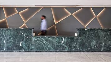 A reception area with marble counters and a geometric wall design.