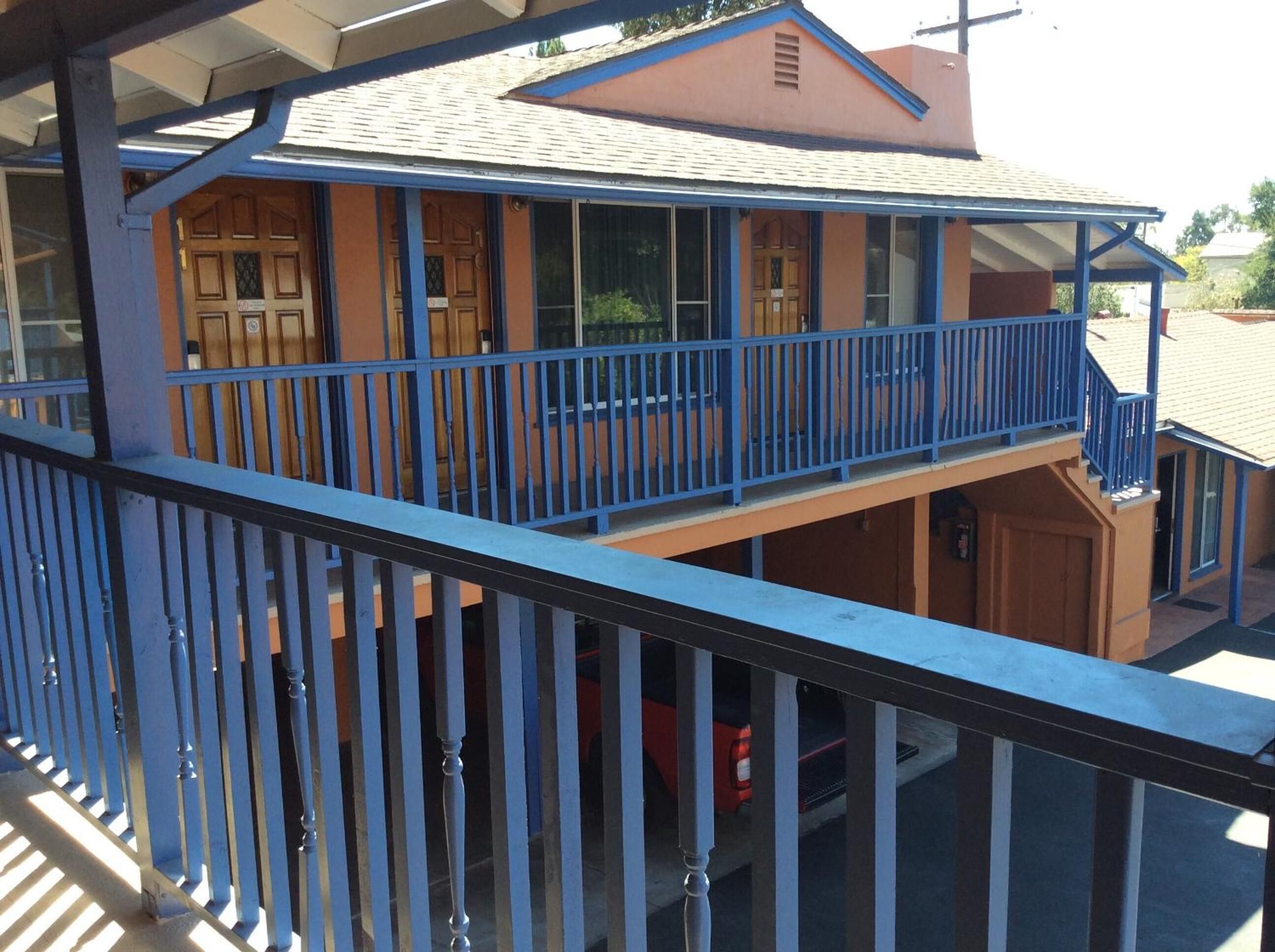 A two-story building with a balcony and a covered area.