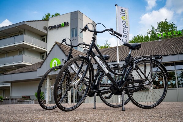 Una bicicleta estacionada frente a un edificio con un letrero que dice 'Campanile Hotel Restaurant'.