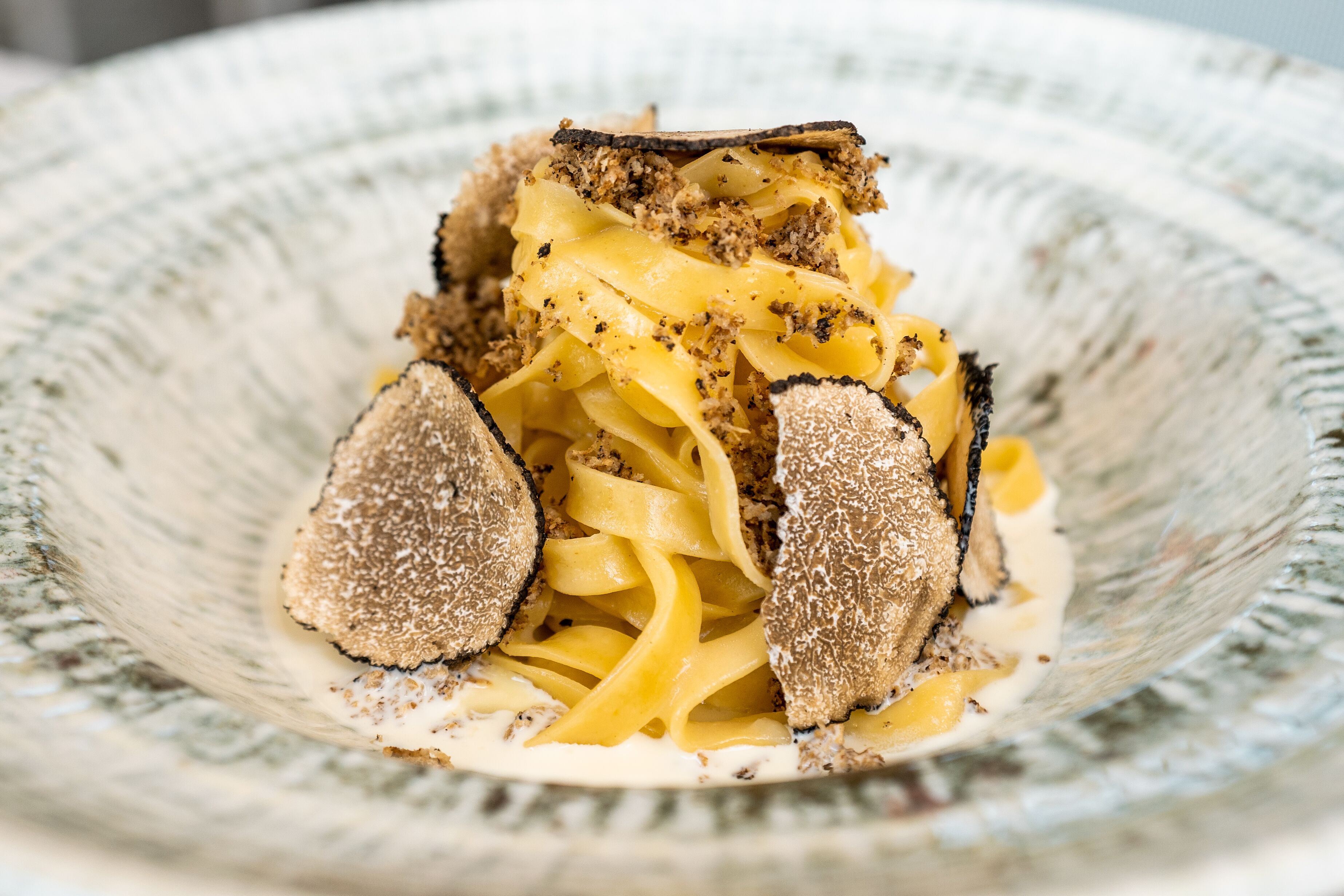 A bowl of pasta with truffles.