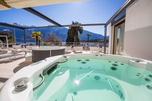 Un jacuzzi con vistas despejadas a montañas y un lago.