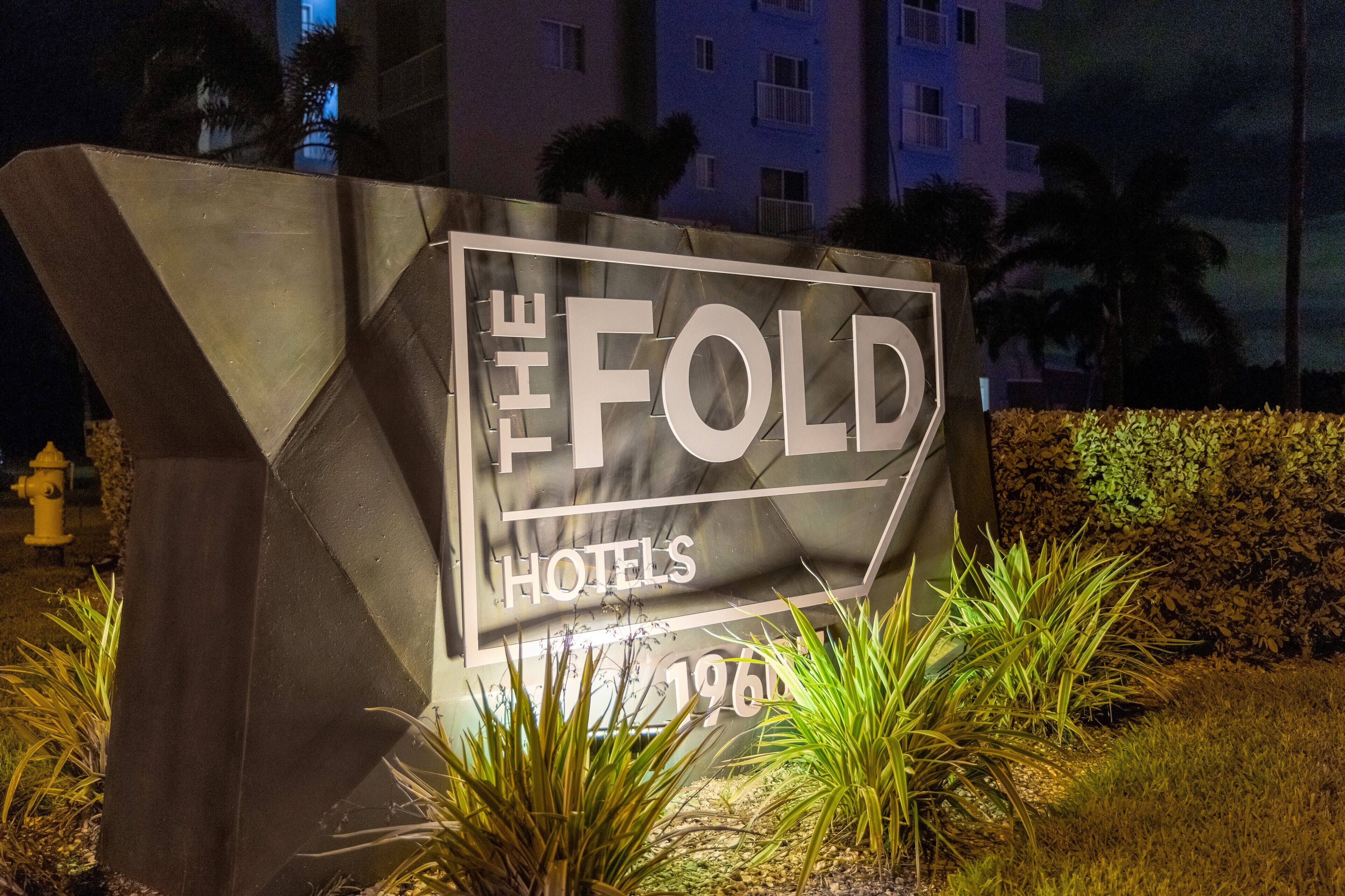 Señal de 'The Fold Hotels' con un diseño geométrico y la fecha '1960' visible.