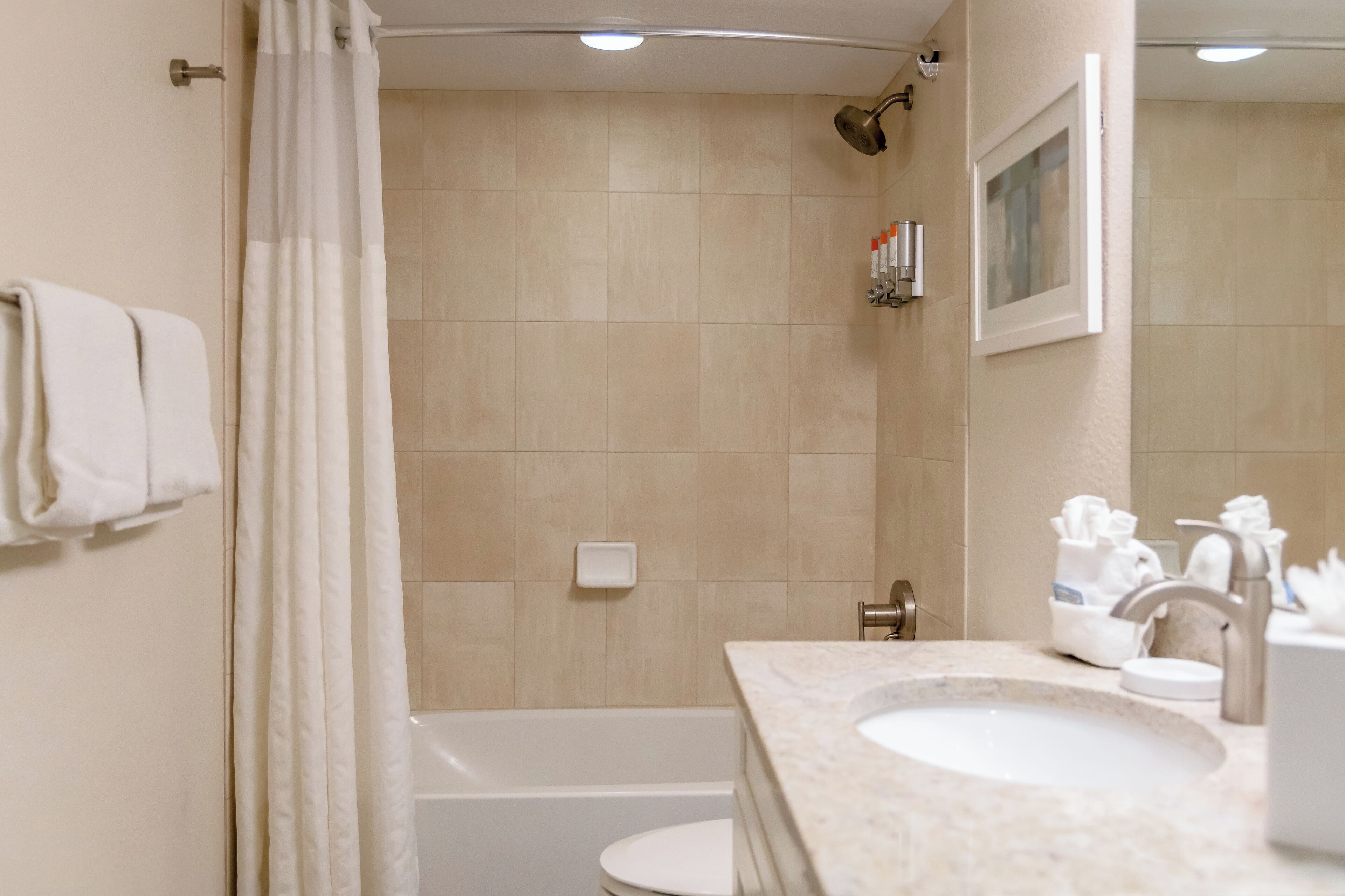 A bathroom with a bathtub, a sink, and a shower curtain.