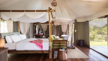 A spacious bedroom with a large bed, wooden headboard, and a view of the outdoors.