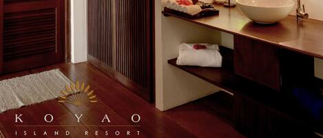 A wooden ceiling with woven patterns, a wooden door, a white sink with a bowl, and a mirror.