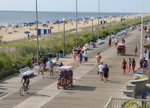 A boardwalk with people walking, a bicycle, and a cart. - Atlantic Sands Hotel & Conference Center (Rehoboth Beach)