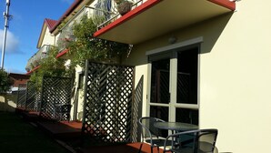 A residential building with a balcony, a window, and a table with chairs. - New Castle Motor Lodge (Rotorua)