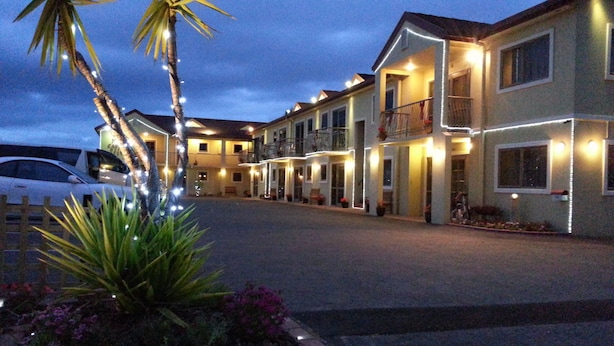 A hotel with multiple floors, balconies, and a well-lit entrance. - New Castle Motor Lodge (Rotorua)