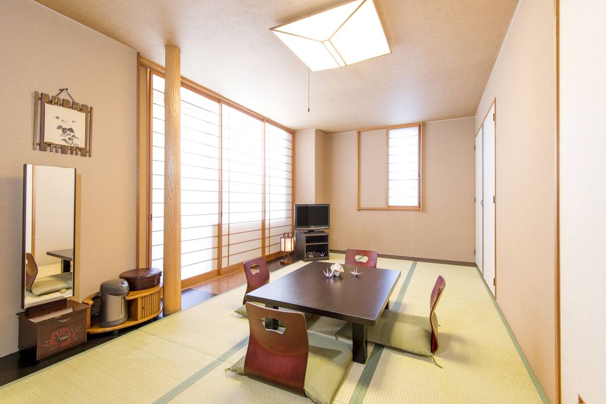 A traditional Japanese-style room with tatami flooring, a low table, and sliding doors.
