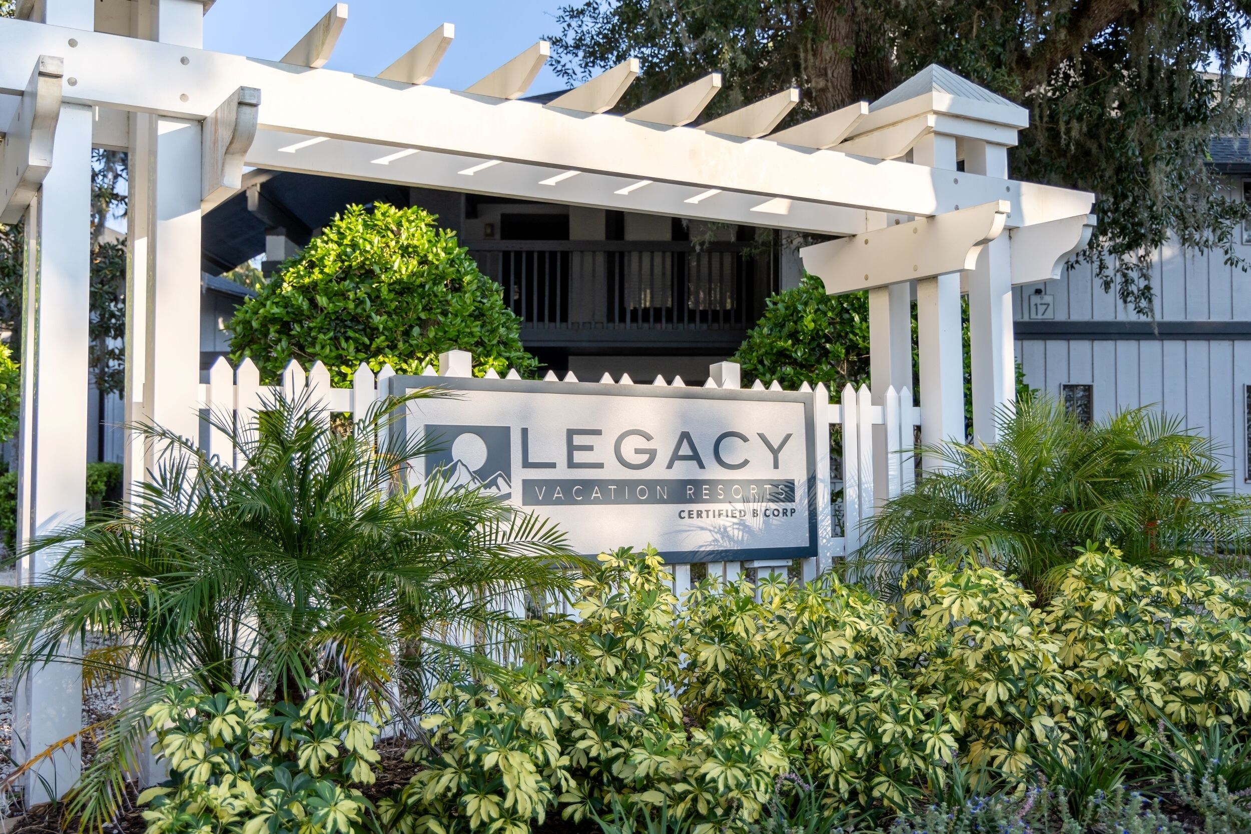 A white pergola structure with a sign for Legacy Vacation Resorts.