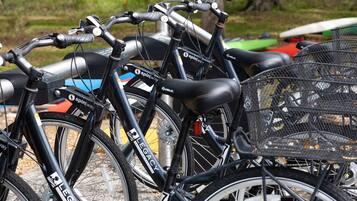 Uma fileira de bicicletas com cestas, identificadas como “spinway” e “legacy”, estacionadas juntas.