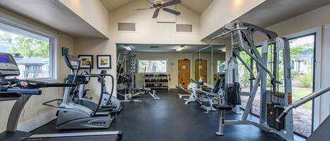A gym with treadmills, weight machines, and a ceiling fan.