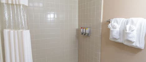 Un baño con bañera, cortina de ducha y toallero con toallas.